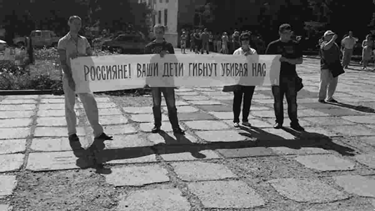 The words in the picture, “Russians! Your children die while murdering us”